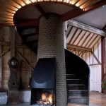 Old-barn-with-steel-spiral-staircase-around-fireplace